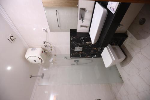 a white bathroom with a toilet and a sink at AIRPORT HOTEL ELEVATE NEAR Delhi Airport WITH- Free Airport PICKUP in New Delhi