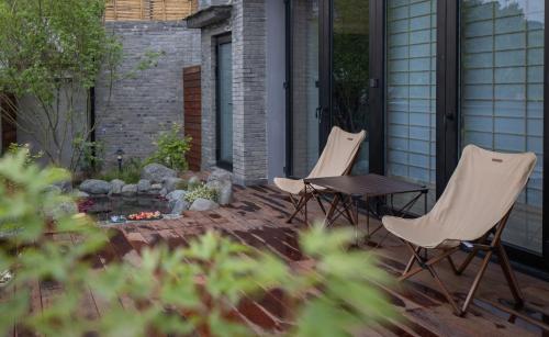 three chairs and a table on a patio at 北京一瓢客栈 Beijing YiPiao Inn in Beijing