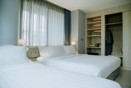 two beds sitting next to each other in a bedroom at BlueSotel Krabi AoNang Beach in Ao Nang Beach