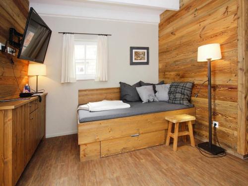 a room with a bed with a tv and a table at Semi-detached houses, turf house in Torfhaus