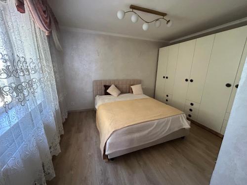 a small bedroom with a bed and a window at Piccolo Mondo in Chişinău