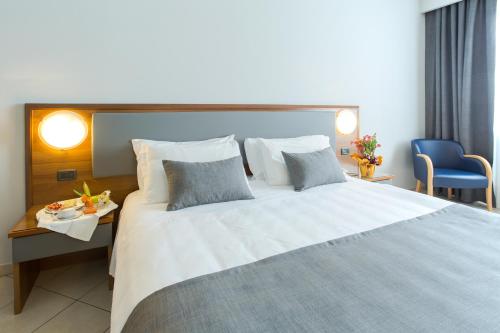 a bedroom with a large bed with a blue chair at Blu Hotel - Sure Hotel Collection by Best Western in Collegno