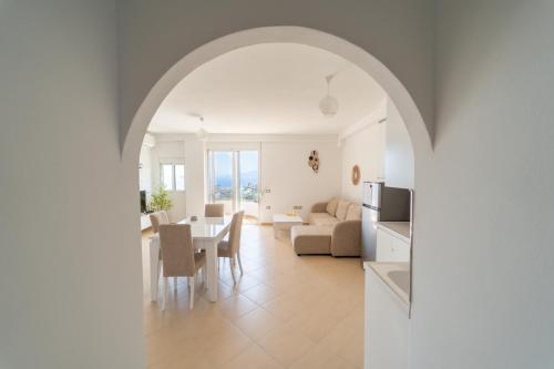 Una cocina y una sala de estar con una mesa y un sofá. en Villa Er Deti, en Sarandë