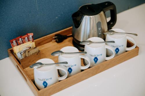 a tray of mugs and a tea kettle on a counter at BlueSotel Krabi AoNang Beach in Ao Nang Beach