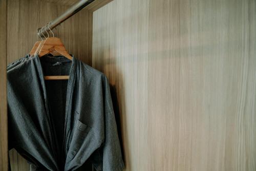 a black jacket hanging on a wooden wall at BlueSotel Krabi AoNang Beach in Ao Nang Beach