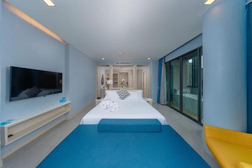 a large bedroom with a large bed and a tv at BlueSotel Krabi AoNang Beach in Ao Nang Beach
