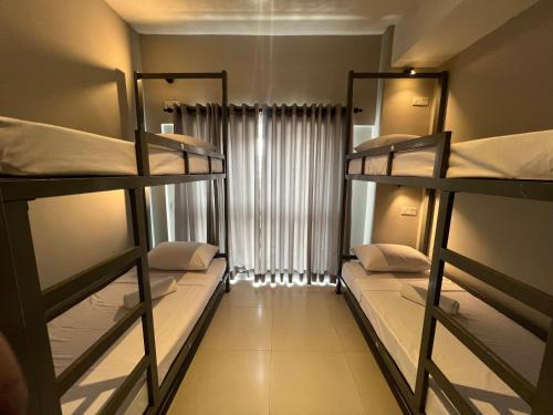 a room with three bunk beds and a window at Candea Cocoon Kandy in Kandy