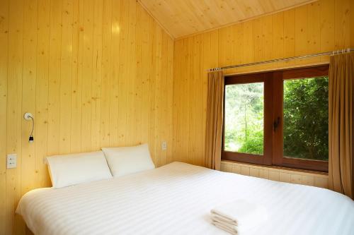 a bed in a room with a window at Tom's Du Già Homestay in Làng Cac