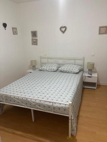 una camera da letto con un letto con due comodini e due lampade di Centre ville a Nizza