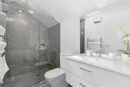a bathroom with a shower and a toilet and a sink at Handy Riccarton New Home Walk to Westfield, Tower Junction & Close to Hagley Park in Christchurch