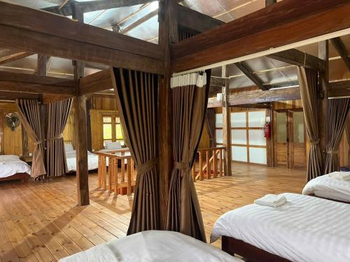 a large room with two beds and a table at Tom's Du Già Homestay in Làng Cac