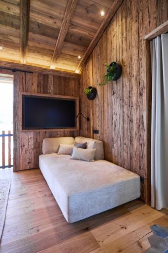 a large bed in a room with wooden walls at Ziegelberg Chalets in Füssen