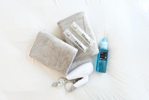 a group of items on a bed with a bottle of soap at Geisha Blue IMAIKE 2 in Nagoya