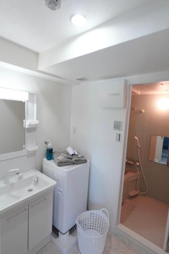 a white bathroom with a sink and a refrigerator at Geisha Blue IMAIKE 2 in Nagoya