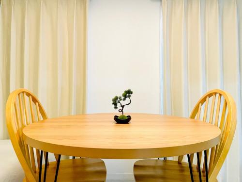 a wooden table with two chairs and a potted plant on it at Geisha Blue IMAIKE 2 in Nagoya