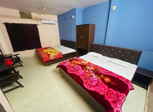 ウダイプールにあるHotel vallabh darshanの青い壁の部屋にベッドが2つある