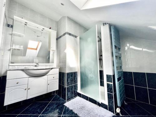 a bathroom with a sink and a glass shower at Chez Marilou in Sprimont