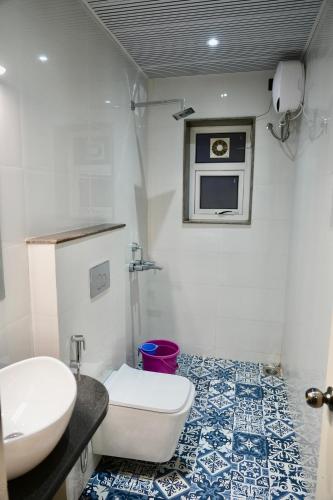 a bathroom with a toilet and a sink and a microwave at Lillas White house in Arpora
