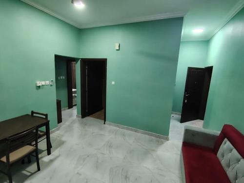 a room with blue walls and a table and a couch at Al Rawas furnished Apartment in Salalah