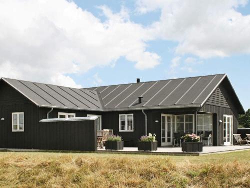 a black house with a gray roof at 10 person holiday home in Nysted-By Traum in Nysted