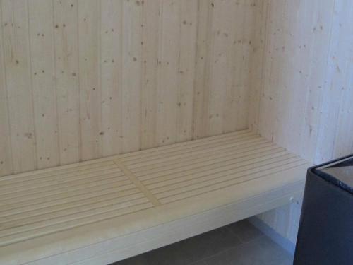 a wooden bench in a corner of a room at 10 person holiday home in Nysted-By Traum in Nysted