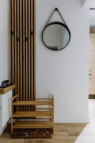 a wooden bench sitting next to a white wall at Nook Apartment Zamość Old Town in Zamość