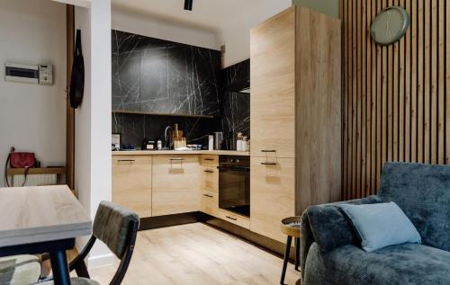 a living room with a couch and a kitchen at Nook Apartment Zamość Old Town in Zamość