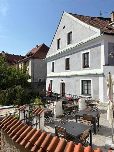 a white building with tables and chairs in front of it at Hotel Barbakan in Český Krumlov