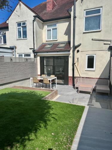 a patio with a table and chairs in front of a house at Recently renovated 3 bed home in Southampton