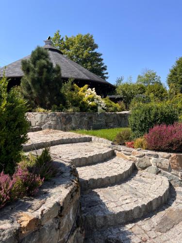 a stone path in a garden with a house in the background at Nowa Prowansja 