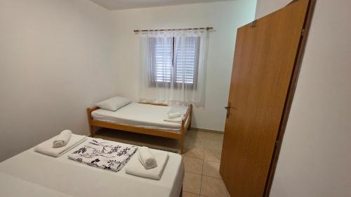 a small room with two beds and a window at Beachfront House Nella with full privacy in Jasenice