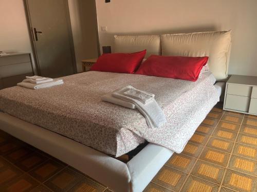 a bed with red pillows and towels on it at La Vista in Otricoli