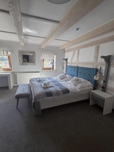 a bedroom with a large bed with a blue headboard at Nowa Prowansja 