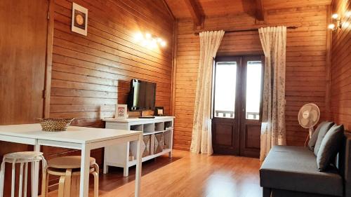 a living room with a table and a tv at Casas de Montanha da Gralheira in Gralheira
