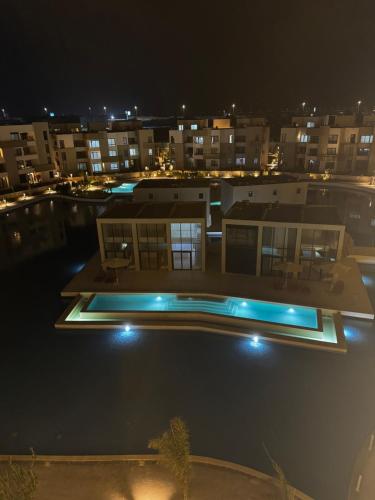 a swimming pool at night with buildings in the background at Cabin in zahra elalamein in El Alamein