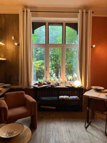 a living room with a large window and a couch at La Roseraie in Tournai
