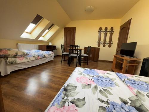 a room with two beds and a dining table at Babie Lato in Włodarka