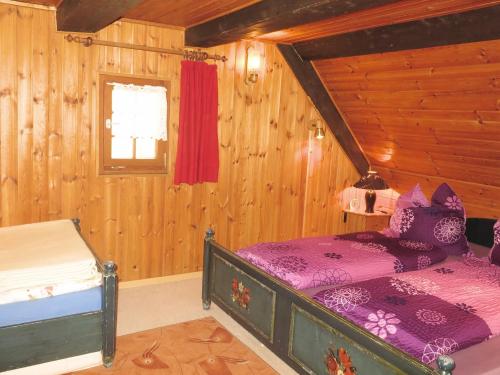 une chambre avec un lit dans une cabane en bois dans l'établissement Ferienhaus, Schwarzwald, à Sankt Georgen im Schwarzwald