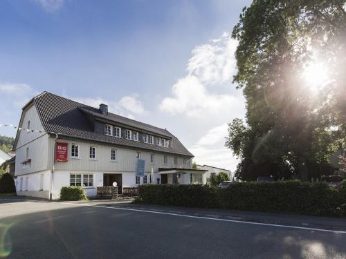 a white building with the sun in the sky at Winterberg Gruppenhaus mit Sauna ideal für Familien & Freunde in Winterberg