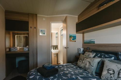 a bedroom with a bed with a blue comforter at Serenity in Saint Erth