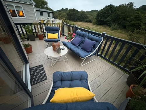 a balcony with two blue chairs and a table at Serenity in Saint Erth