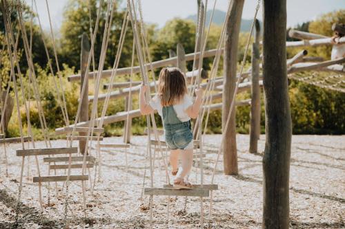 a little girl on a swing in a park at Kaiserlodge in Scheffau am Wilden Kaiser