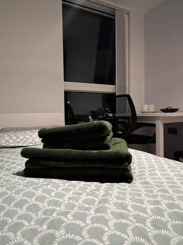 a pile of green towels sitting on top of a bed at Riverside Figs in Manchester