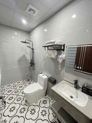 a bathroom with a toilet and a sink at Royal Hotel in Móng Cái