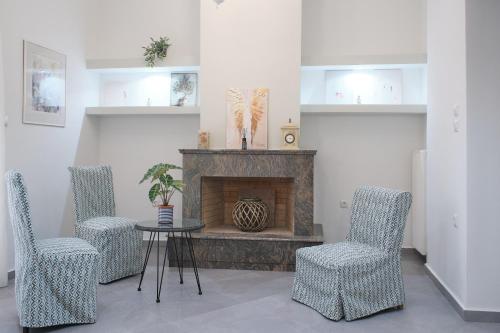 a living room with a table and chairs and a fireplace at Olivia 42 in Nafpaktos