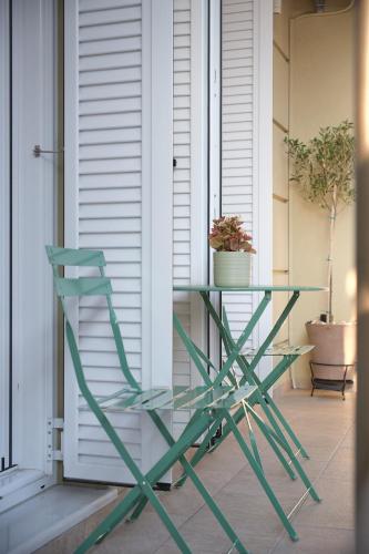 a green glass table and a chair on a porch at Olivia 42 in Nafpaktos