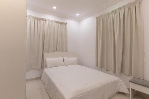 a white bedroom with a bed and a window at شقة الصواري الفاخرة in Jeddah