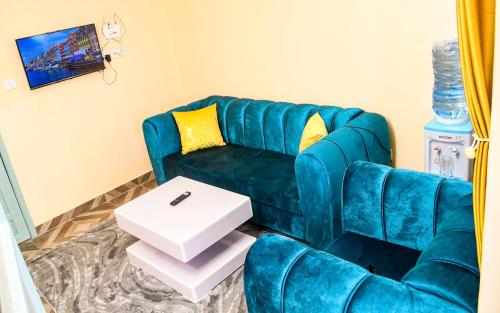 a living room with a blue couch and a table at Haven homes in Naivasha