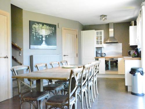 a kitchen and dining room with a wooden table and chairs at Forest Cottage, Jehonville in Jehonville