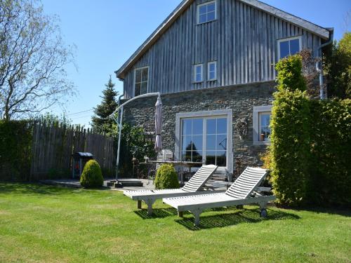 two white chairs in a yard in front of a house at Forest Cottage, Jehonville in Jehonville